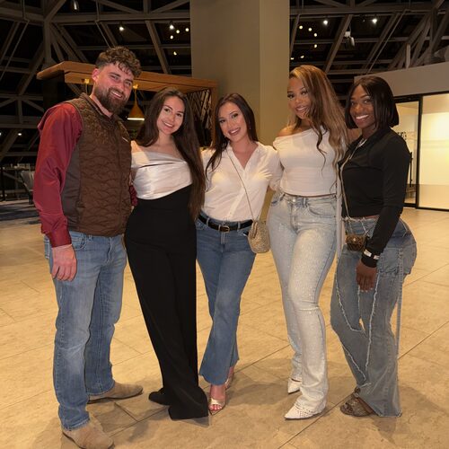 Five Winners Crest Agency team members smiling together on a team night out